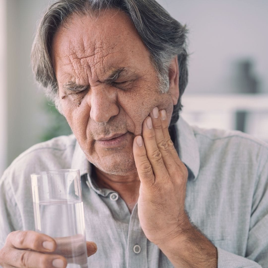Feature Image - Is Tooth Loss A Normal Part of Ageing - man holding jaw